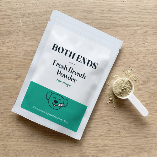 Both Ends Fresh Breath Powder pouch with its small white measuring scoop and a little powder on a kitchen worktop